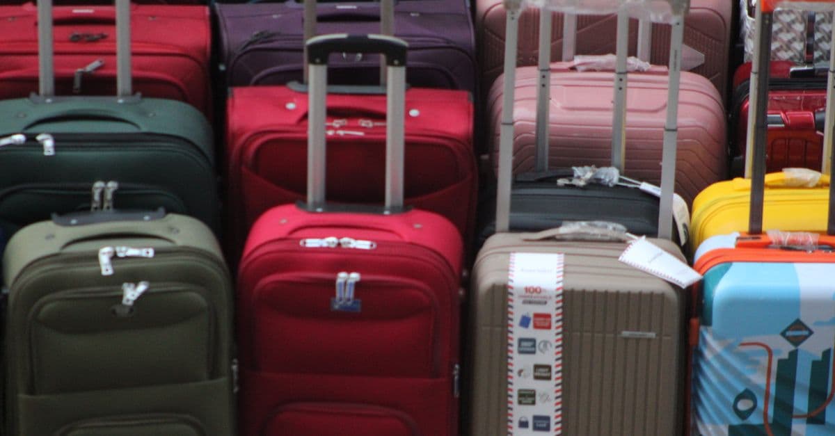 A vibrant collection of various suitcases stacked in preparation for travel.