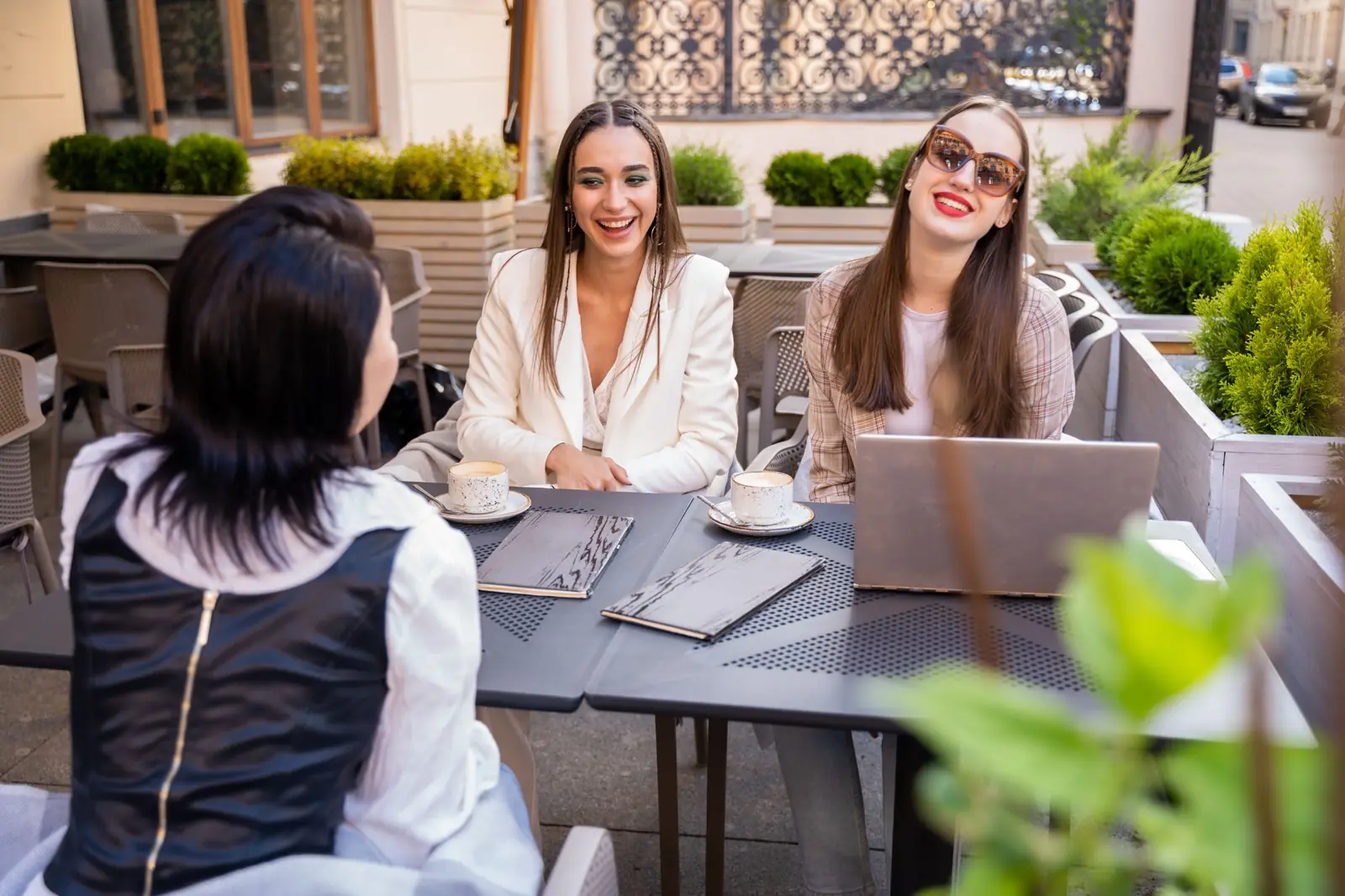 Friends sharing travel plans at an outdoor café